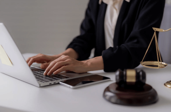Professional working on a laptop beside legal gavel symbolising IT support for law firms and secure legal technology systems.