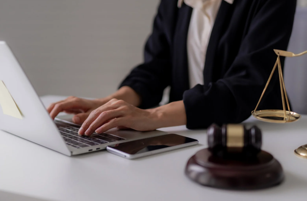 Professional working on a laptop beside legal gavel symbolising IT support for law firms and secure legal technology systems. 
